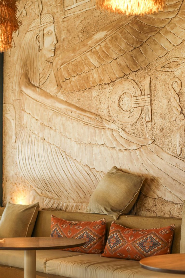 Elegant interior with an ancient Egyptian wall sculpture and cozy seating.